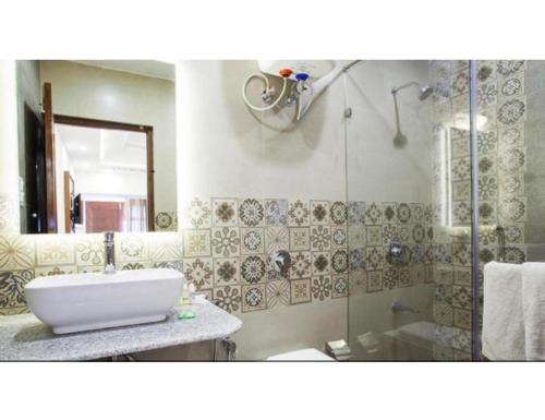 a bathroom with a sink and a shower at Hotel Valley View, Mussoorie in Mussoorie
