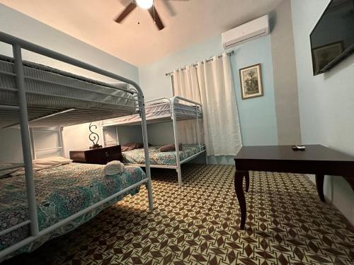 a bedroom with two bunk beds and a piano at Best Surfers Beach just a few block down, Arecibo Main House in Arecibo