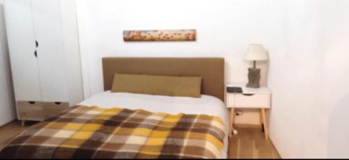 a bedroom with a bed with a plaid blanket at Da Nori bed and relax in Orbetello