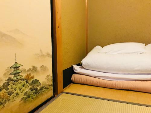 Cama o camas de una habitación en Nagomi-Ryokan Yuu