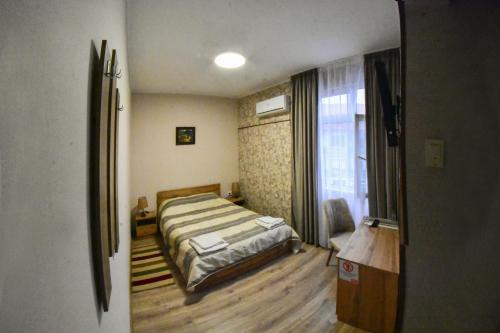 a bedroom with a bed and a window at Hotel Rade 1 in Vratsa