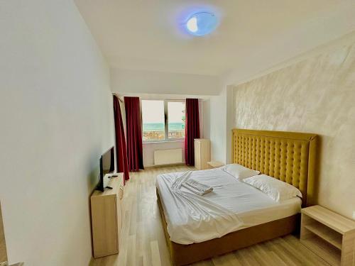 a bedroom with a bed and a large window at Summerland Seaview Apartments in Mamaia