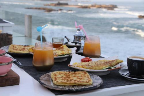 una mesa cubierta con platos de comida y bebida en Hostel La Smala, en Essaouira