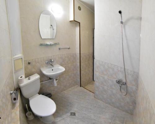 a bathroom with a toilet and a sink and a shower at Hotel Rade 1 in Vratsa