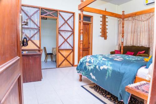 a bedroom with a bed with a blue comforter at Art and Leisure-EB Hotel in Takoradi