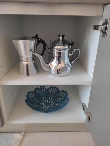 a tea kettle and a plate on a shelf at DLX03 - Appartement Deluxe 2 chambres - Centre Ville Oujda in Oujda