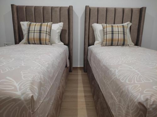 two beds sitting next to each other in a room at DLX03 - Appartement Deluxe 2 chambres - Centre Ville Oujda in Oujda