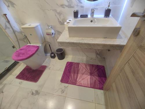 a bathroom with a white sink and a toilet and a sink at DLX03 - Appartement Deluxe 2 chambres - Centre Ville Oujda in Oujda