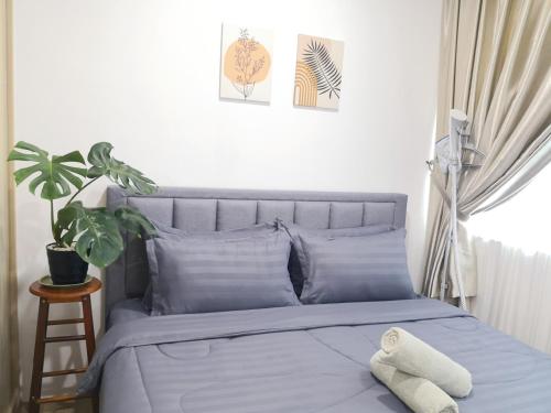 - une chambre dotée d'un lit avec des draps bleus et une plante dans l'établissement Hanns&KingBed&WIFI@ComfortStay4, à Sibu