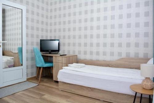 a hotel room with a bed and a television at Hotel Rade 1 in Vratsa