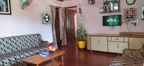 ein Wohnzimmer mit einem Sofa und einem Tisch in der Unterkunft Roam Alone Roomstay near International airport in Gurpur