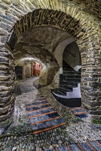 a stone archway with stairs in a building at Alloggio U SPORTEGU DA E MONTI A GIAIA in Badalucco
