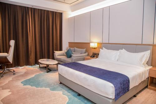um quarto de hotel com uma cama grande e um sofá em LC International Hotel 
