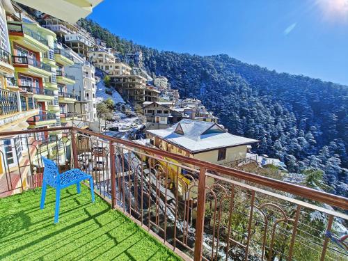 a blue chair sitting on the balcony of a building at Frosty Woods Homestay in Shimla