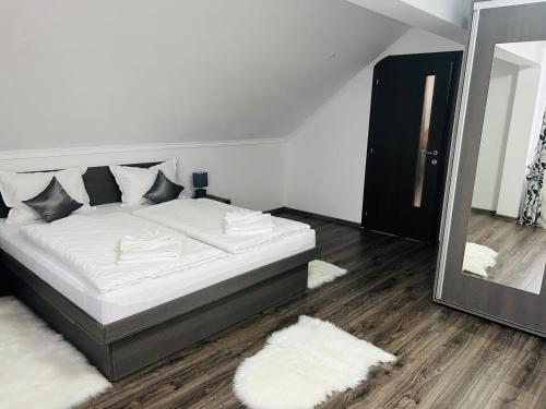 a bedroom with a large bed and a mirror at Casa Potcovarului in Drăguş