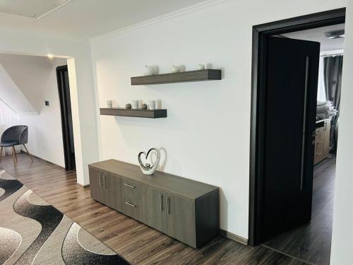 a living room with a table and a mirror at Casa Potcovarului in Drăguş