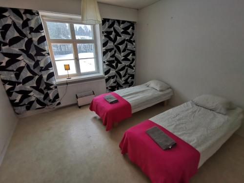una camera da letto con due letti e una finestra di Beautiful 2 Bed Apartment Sauna Facility in Kotka a Kotka