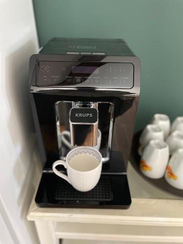 a coffee maker with a cup on top of it at Pension Casa del Sol Predeal in Predeal