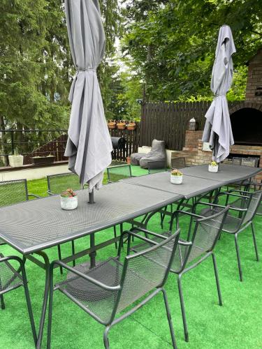 a picnic table with two chairs and an umbrella at Pension Casa del Sol Predeal in Predeal