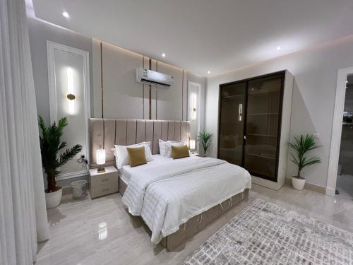 - une chambre avec un grand lit et une grande fenêtre dans l'établissement Riyadh almajidiya appartment, à Riyad