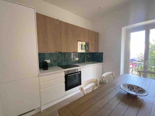 une cuisine avec des armoires blanches et une table en bois dans l'établissement Nice design flat on the Old Port-Marseille, à Marseille