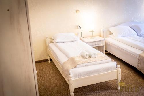 a bedroom with two beds and a night stand with two towels at Hotel Kiev in Veliko Tŭrnovo