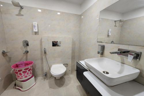 uma casa de banho com um lavatório, um WC e um espelho. em Hotel Mandakini Royale em Kanpur