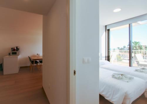 - une chambre avec un lit et un balcon avec une table dans l'établissement Denia Beach - Ático en Primera Línea by Costablancarent Rentals, à Dénia