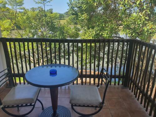 a blue table and two chairs on a balcony at Rain Farm Game Lodge in uMhlali