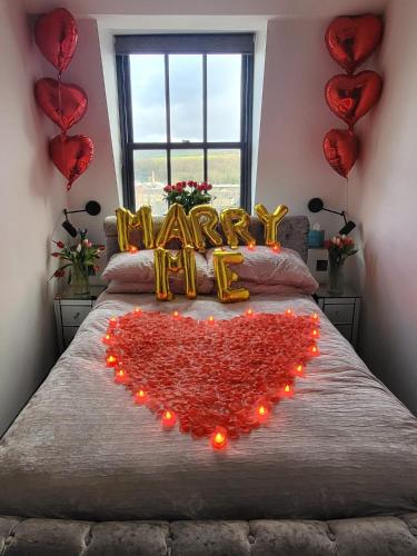 a bed with a heart made out of hearts at The Arches Apartments Kendal in Kendal