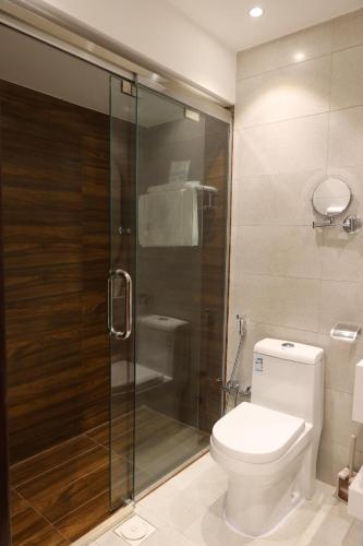 a bathroom with a toilet and a glass shower at جوهرة دومة الجندل للشقق المخدومة Jawharat Dumat Serviced Apartments in Dawmat al Jandal