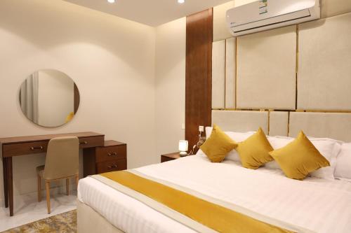 een slaapkamer met een bed, een bureau en een spiegel bij جوهرة دومة الجندل للشقق المخدومة Jawharat Dumat Serviced Apartments in Dawmat al Jandal