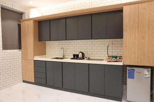a kitchen with black cabinets and a sink at جوهرة دومة الجندل للشقق المخدومة Jawharat Dumat Serviced Apartments in Dawmat al Jandal