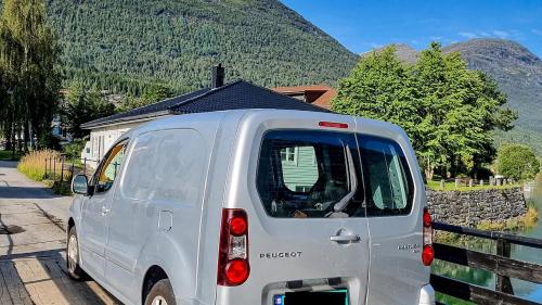 a white van parked in front of a house at Electric Minicamper blue in Askøy