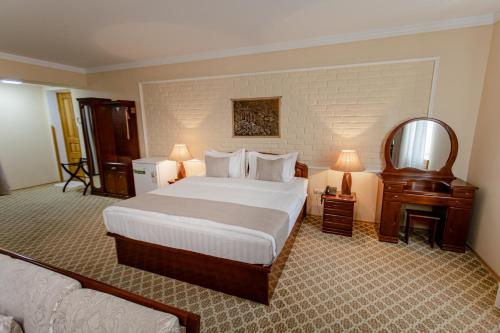 a hotel room with a large bed and a mirror at Hotel Grand Samarkand Superior - B in Samarkand