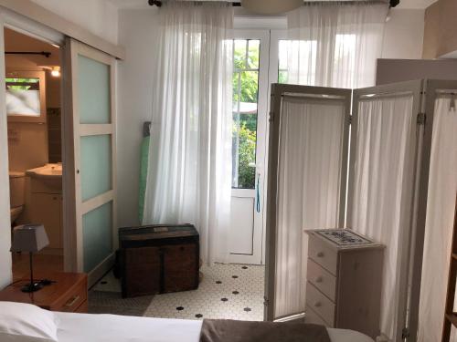 - une chambre avec un lit et une porte menant à une fenêtre dans l'établissement vacances-esprit-cabanes, à Andernos-les-Bains