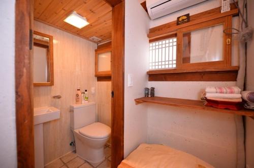 a small bathroom with a toilet and a sink at Jeonju Nostalgic Home in Jeonju