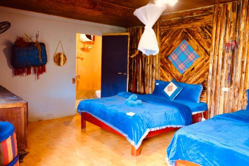 a bedroom with two beds with blue sheets at La Beauté Bắc Hà in Bắc Hà