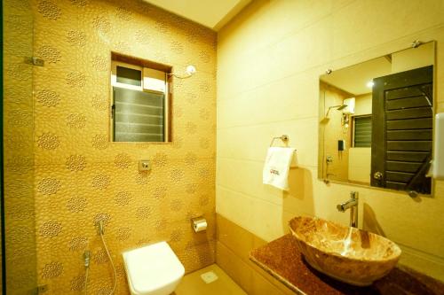 a bathroom with a sink and a toilet at Coconut Greenland Resort in Nagaon