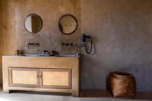 a bathroom with a sink and two mirrors at Life Gallery Hotel & Spa in Korçë