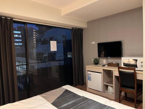 a hotel room with a desk and a television at Le Tour Hotel Akihabara Kanda 楽途ホテル神田秋葉原 in Tokyo