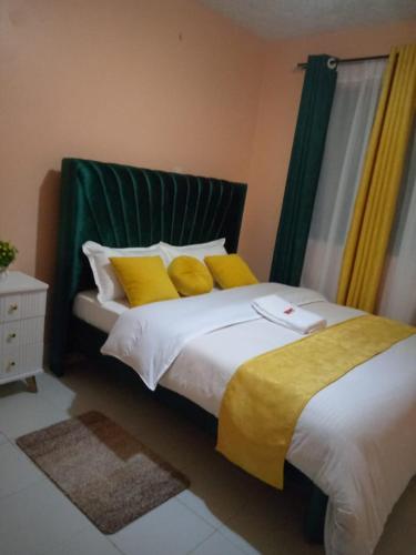 a bedroom with a large bed with yellow pillows at Embu Paradise 1 bedroom AirBNB in Embu