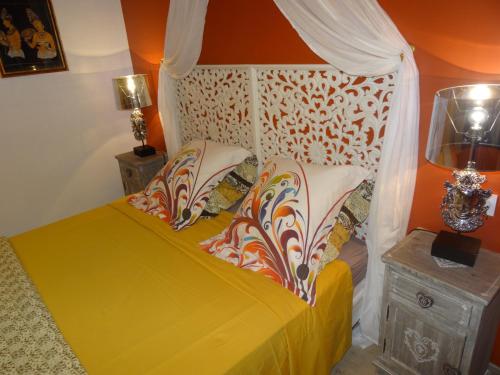 a bedroom with a yellow bed with a canopy at La Fontenelle Chambres d'Hôtes in Sainte-Sévère