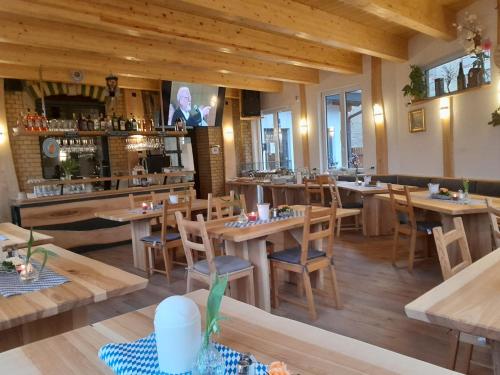 a restaurant with wooden tables and chairs and a bar at Ferienanlage Markus Nitsch in Bärenstein