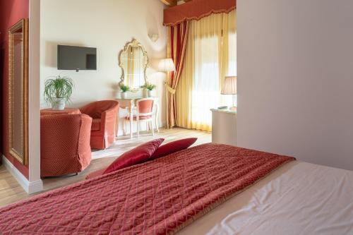 a bedroom with a bed with a red comforter at Hotel Canova Sport & Relax in Cavaso del Tomba