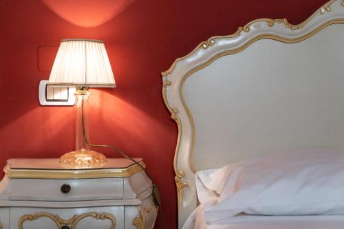 a lamp on a night stand next to a bed at Hotel Canova Sport & Relax in Cavaso del Tomba