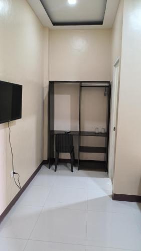 an empty room with a tv and a chair at Eva's Guest House in Bais