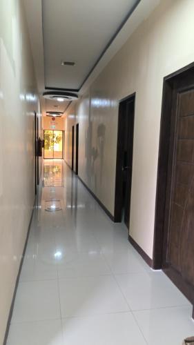 a hallway of a building with doors and tile floors at Eva's Guest House in Bais