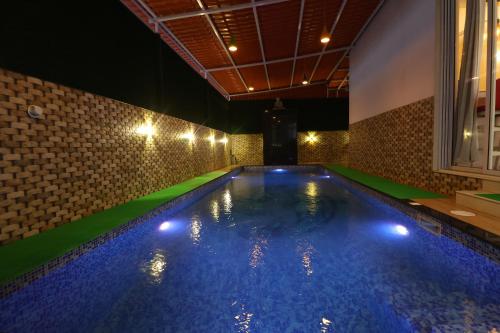 een zwembad met blauw water in een kamer bij PARADISE VILLA in Lonavala
