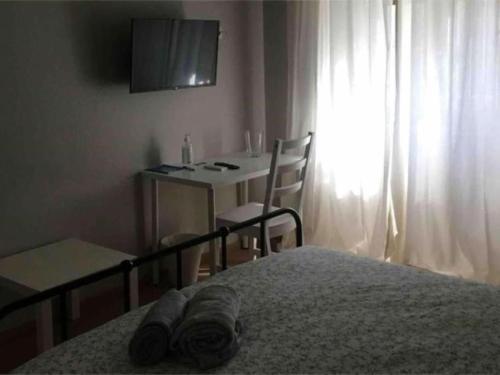 um quarto com uma cama, uma mesa e uma secretária em Arina Home -Aeroporto Fontanarossa- em Catânia